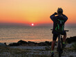 Un uomo in bicicletta fotografa un alba meravigliosa
