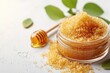 Homemade lip scrub using brown sugar honey and olive oil on a white background