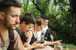 © Julian - group of woman and man looking at cellphones in while sitting in forest