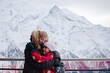 Senior woman and a young girl share a heartfelt embrace against the stunning alpine scenery, adventures in the snowy mountains. Family bonds. Active vacations