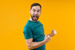 © wpadington - Portrait of joyful young man with wide open mouth and clenched fists celebrating money win in online lottery or at bookmaker's, isolated over yellow background