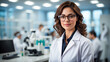 © Imagynr - Beautiful young woman scientist wearing a white coat and glasses in a modern Medical Science Laboratory with a Team