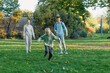 © andreiko - a family mom and 2 sons are having fun, running in the park and jumping. Sons, children, mom, run, play, rejoice, enjoy nature in summer. Family teamwork. Happy family team, running together in field