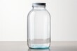 Transparent empty glass water bottle with lid. White backdrop. Concept of environmental health, refillable water containers, and plastic alternatives.