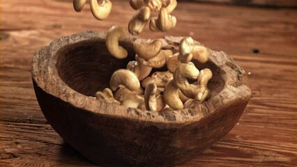 Canvas Print - Cashews fall into a wooden bowl. Filmed on a high-speed camera at 1000 fps. High quality FullHD footage