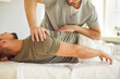 © Studio Romantic - Male masseur gives a relaxing back massage therapy, relieves tension and pain. Man lying on couch, chiropractor stretch back using healing techniques. Muscular treatment, rejuvenation procedure.