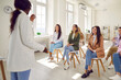 © Studio Romantic - Young diverse women meeting with team coach in office workplace. Happy well humoured multiethnic female audience laughing at good joke that woman speaker shares during business training presentation