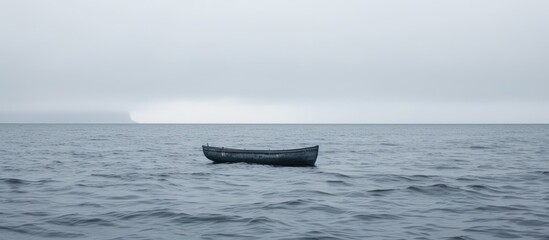 Wall Mural - Glimpse of faraway boat on rippling sea on a gray day