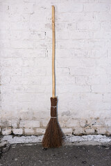 Broom near a brick wall