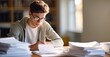 © Stock Pix - 'Focused young student overwhelmed with study materials, preparing for an exam in a warmly lit room.'