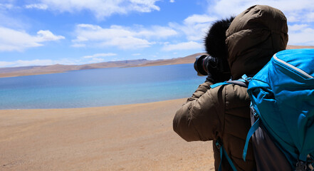 Wall Mural - Woman photographer taking phtoto hiking in beautiful winter high altitude mountains