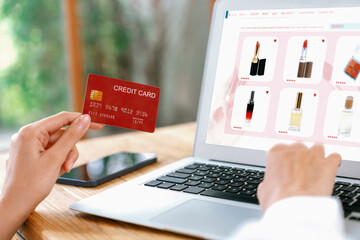 Woman shopping online on internet marketplace browsing for sale items for modern lifestyle and use credit card for online payment from wallet protected by uttermost cyber security software