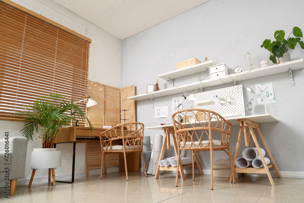 Sketches of stylish accessories with tools on jeweler table in workshop