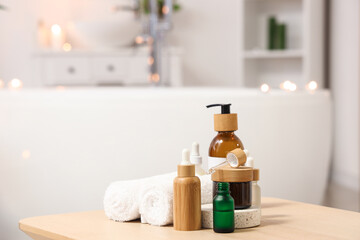 Bottles of skincare products with towels on table in bathroom, closeup