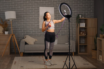 Poster - Female Asian sports blogger with skipping rope recording training video at home