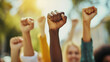 © Davin - Close up hands of multi ethnic people raising their fists up in the air. People diversity and equality concept.