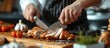 © AkuAku - Chef slicing chicken leg for meat recipes on culinary blog or show.