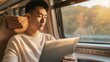 © mariiaplo - Smiling Asian man reading on a tablet while traveling by train
