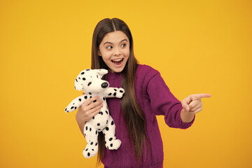 Poster - Excited face. Childhood, toys and kids. Cute teen girl cuddling fluffy toy. Amazed expression, cheerful and glad.