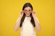 Woman feeling cool and awesome. Excited happy funny young woman in party glasses on a yellow bright background.