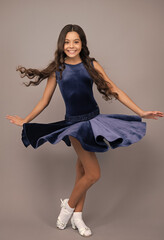 Poster - Teenager portrait with movement dress. Young teen child with flowing skirt. Teen girl fluttering dress in motion, isolated on gray. Happy girl face, positive and smiling emotions.