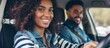 © AkuAku - The young woman happily improves her driving skills with the help of an instructor holding a clipboard.