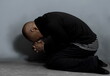 man praying in poverty on the floor stock image with no help crying alone and all by himself on white background stock photo	