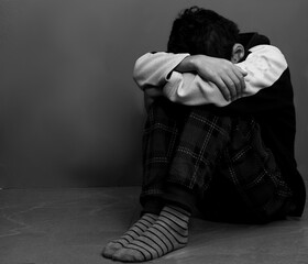 Wall Mural - boy praying in poverty on the floor stock image with no help crying alone and all by himself on white background stock photo	