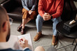 © TrueFrame Collective - High angle selective focus shot of unrecognizable married couple sitting on couch in front of psychologist during therapy session
