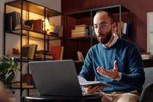 Medium Portrait Of Modern Middle Eastern Psychologist Holding Notebook Sitting In Front Of Laptop Talking To Patient Through Video Call