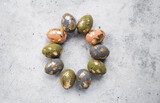 Fototapeta Desenie - Stylish beautiful Easter eggs with golden potali coating on a gray background. The concept of happy Easter 2024.