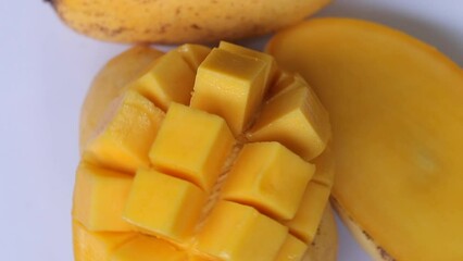 Wall Mural - Rotation of ripped mango slice cubes cut, Mango half cut in cubes, Fresh juicy mango fruit