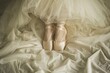 ballet slippers on, dancers legs under a tullestuffed comforter