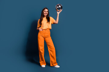 Sticker - Full body size photo of girl dressed orange outfit hold discoball demonstrate retro object at party isolated on dark blue color background