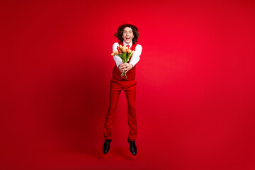 Poster - Full length photo of jumping boyfriend need to give you his tulips bouquet surprise wearing glamour look isolated on red color background