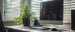 © Ai Studio - Workday serenity; a tidy desk with a computer and a vibrant potted plant by the window