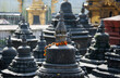 Kleine Stupas und Grabstätten einer heiligen buddhistischen und hinduistischen Gebetsstätte am Stadtrand von Kathmandu, Nepal, Asien, Affentempel,  geschmückt mit orangen Blüten, alte Traditionen 