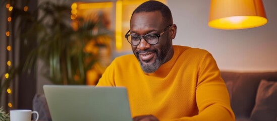 Mature black man utilizes technology for online work, shopping, and banking at home office.