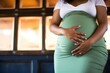 pregnant lady in gentle prenatal pose, hand on belly inside sauna