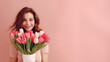 Beautiful pretty girl with hair hold tulips flowers on March 8th International Women's Day on one color background
