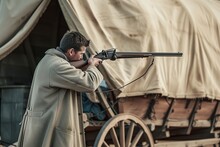 Man In A Duster Coat Loading A Rifle Near A Covered Wagon