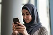 © primopiano - arab woman in a modern hijab using a smartphone