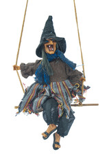 Doll of Baba Yaga on swing isolated on white background