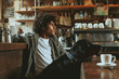 Portrait of a young mixed raced man with his dog in dogs friendly cafe. 