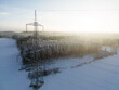 Power lines in front of a snow-covered forest seen from above