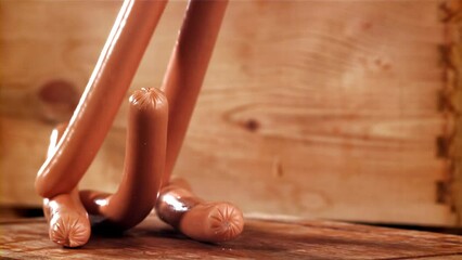 Sticker - Sausages fall on a wooden table. Filmed on a high-speed camera at 1000 fps. High quality FullHD footage