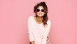 woman wearing sunglasses in front of pink background. beautiful woman with pink top wearing sunglasses and posing in front of camera. woman with sunglasses portrait