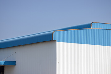 Canvas Print - white and blue metal factory with blue sky background. large metal cargo.