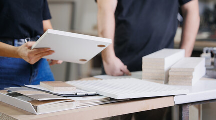 Consultant Woman seller advising client female with color samples and texture for kitchen furniture