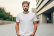 © Fotograf - A man in a white t-shirt standing on a sidewalk. Suitable for various applications